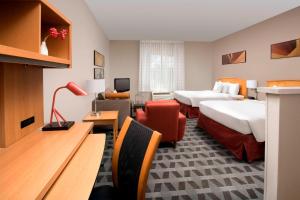 a hotel room with two beds and a couch at TownePlace Suites by Marriott Albuquerque Airport in Albuquerque