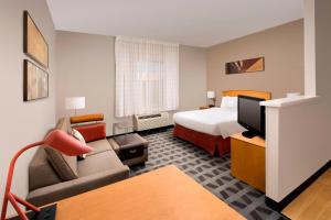 a hotel room with a bed and a couch at TownePlace Suites by Marriott Albuquerque Airport in Albuquerque