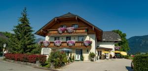 une maison avec des boîtes de fleurs sur le balcon dans l'établissement Gästehaus Kloibergütl, à Sankt Gilgen