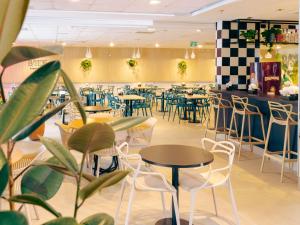 a restaurant with tables and chairs and a bar at ibis Styles Goiania Marista in Goiânia