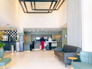 a lobby with two people standing at a counter at ibis Styles Goiania Marista in Goiânia