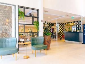 a store with two chairs and a table in a room at ibis Styles Goiania Marista in Goiânia