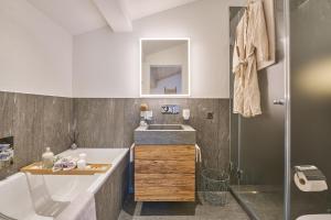 bagno con vasca, lavandino e doccia di WEF in Davos Luxurious Penthouse Apartment a Klosters Serneus