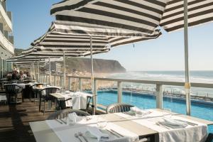 ein Restaurant mit Tischen und Stühlen und Meerblick in der Unterkunft Arribas Sintra Hotel in Sintra