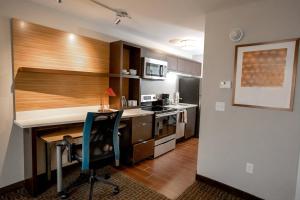 - une cuisine avec un bureau et une chaise dans la chambre dans l'établissement TownePlace Suites by Marriott Louisville Airport, à Louisville