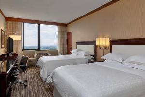 a hotel room with two beds and a window at Sheraton Denver West Hotel in Lakewood