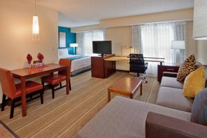 スタッフォードにあるResidence Inn Houston Sugar Land/Staffordのベッドとリビングルームが備わるホテルルームです。