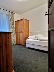 een slaapkamer met 2 bedden en een houten kast bij Pension Baranek - Baranek Resorts in Kaprun