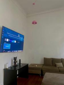 un soggiorno con divano e TV a parete di Casa Vacacional a Buenos Aires