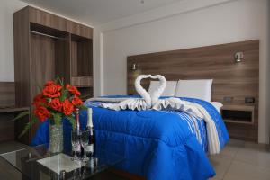 PRIVATE ROOMS - DOWNTOWN AREQUIPA - Adults Only في أريكيبا: غرفة نوم بسرير وبطانية زرقاء وورود