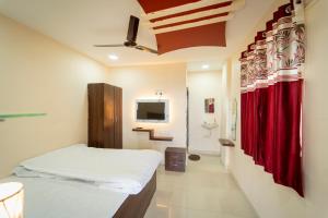 een slaapkamer met een bed en een rood gordijn bij X Western Hills panchagani in Panchgani