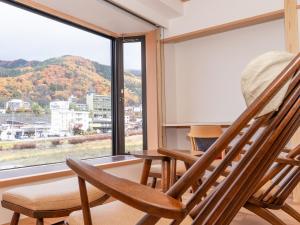 two rocking chairs in a room with a large window at Aburaya Tousen in Yamanouchi