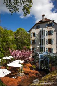 a building with tables and umbrellas in front of it at Hôtel La Maison du Prussien in Neuchâtel