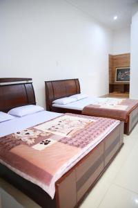 two beds in a room with two bedsitures at Khách sạn Bảo Lộc Garden in Bao Loc