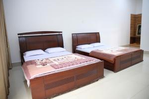 two beds sitting next to each other in a room at Khách sạn Bảo Lộc Garden in Bao Loc