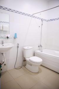 a white bathroom with a toilet and a sink at Khách sạn Bảo Lộc Garden in Bao Loc