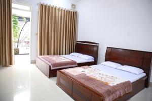 a bedroom with two beds and a window at Khách sạn Bảo Lộc Garden in Bao Loc