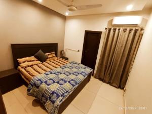 een slaapkamer met een bed en een raam erin bij Elegant Family Apartments Hotel E11 in Islamabad