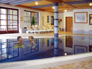 zwei Personen schwimmen im Pool in der Unterkunft Gasthof Bad Hochmoos in Lofer