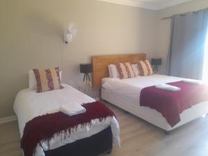 A bed or beds in a room at Cornerstone Guesthouse Alk Van Zyl