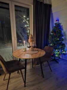 una mesa con una vela y un árbol de Navidad en una habitación en Black Dora, en Yaremche