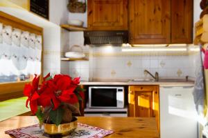 a kitchen with a vase with a red flower on a table at Chalet L'Ange Des Neiges in Valtournenche