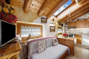 a living room with a couch and a tv in a kitchen at Chalet L'Ange Des Neiges in Valtournenche