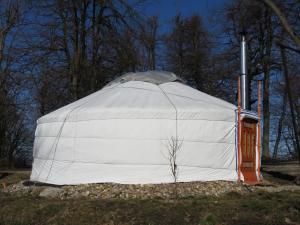 uma grande tenda branca sentada num campo em Dobogókő Jurtaszállás em Dobogoko