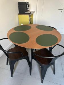 une table en bois entourée de deux chaises noires dans l'établissement Vaste appartement avec parking gratuit et espace de travail, à Illkirch-Graffenstaden