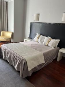 1 dormitorio con 1 cama grande y 1 silla en Rio Maior Hotel, en Rio Maior