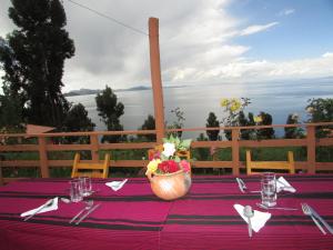 una mesa con un mantel púrpura y una cesta de flores en Titicaca Chaska Wasi Amantani, en Ocosuyo