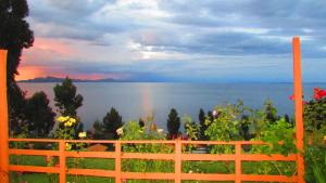 una vista del océano con un arco iris en el cielo en Titicaca Chaska Wasi Amantani, en Ocosuyo