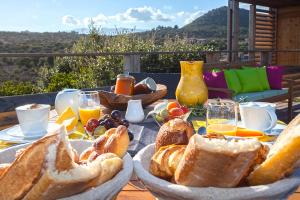 uma mesa de pequeno-almoço com pão e sumo e uma vista em Chambres d'hôtes Casa di l'Oru em Porto-Vecchio