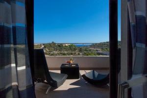 uma vista para uma varanda com uma mesa e cadeiras em Chambres d'hôtes Casa di l'Oru em Porto-Vecchio