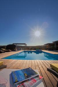 uma piscina com um livro sobre uma mesa em Chambres d'hôtes Casa di l'Oru em Porto-Vecchio