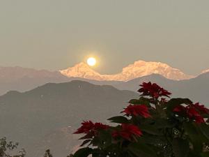 een uitzicht op de bergen met de zon in de lucht bij Hotel Pristine Himalaya in Pokhara