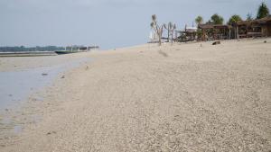 een zandstrand met een huis aan de kust bij Mola2 Resort Gili Air in Gili Air