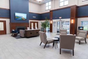 een lobby met een tafel en stoelen en een open haard bij La Quinta by Wyndham Bannockburn-Deerfield in Bannockburn