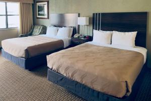 Quality Inn Durango في دورانجو: غرفة فندقية بسريرين وكرسي