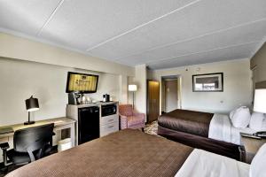 a hotel room with two beds and a desk at Quality Hotel & Suites At The Falls in Niagara Falls