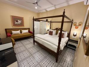 Schlafzimmer mit Himmelbett und Sofa in der Unterkunft The Coral Court Homestay in Agra