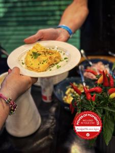 una persona sosteniendo un plato con un pedazo de comida en él en Vienna House Easy by Wyndham Pilsen, en Plzeň