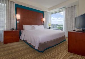 um quarto com uma cama grande e uma televisão de ecrã plano em Residence Inn by Marriott Arlington Ballston em Arlington