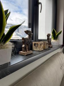 a window sill with plants and figurines on it at Freiraum 9 Living Apartment in Sankt Johann im Pongau