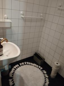 bagno con lavandino e tappeto bianco di Centrala stan 2-rums lägenhet a Umeå