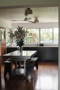 uma cozinha com uma mesa com um vaso de flores em Evendale House em Hastings