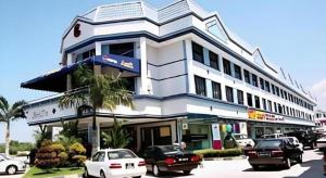 a white building with cars parked in front of it at Grand City Hotel in Bandar Seri Begawan