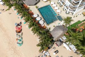 una vista sul mare di una spiaggia con palme e una piscina di Mana Mui Ne Beach Resort & Spa a Mui Ne