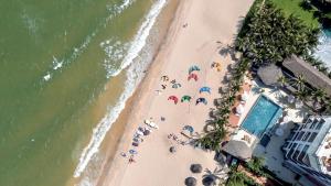 una vista panoramica su una spiaggia con persone con ombrelloni di Mana Mui Ne Beach Resort & Spa a Mui Ne