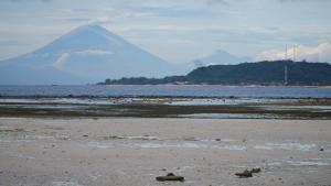 een berg in de verte met een strand en de oceaan bij Mola2 Resort Gili Air in Gili Air